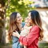 joyful mom holding toddler both laughing together, family photo, natural lighting